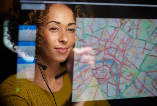 Woman views trucking dispatch map on her computer screen